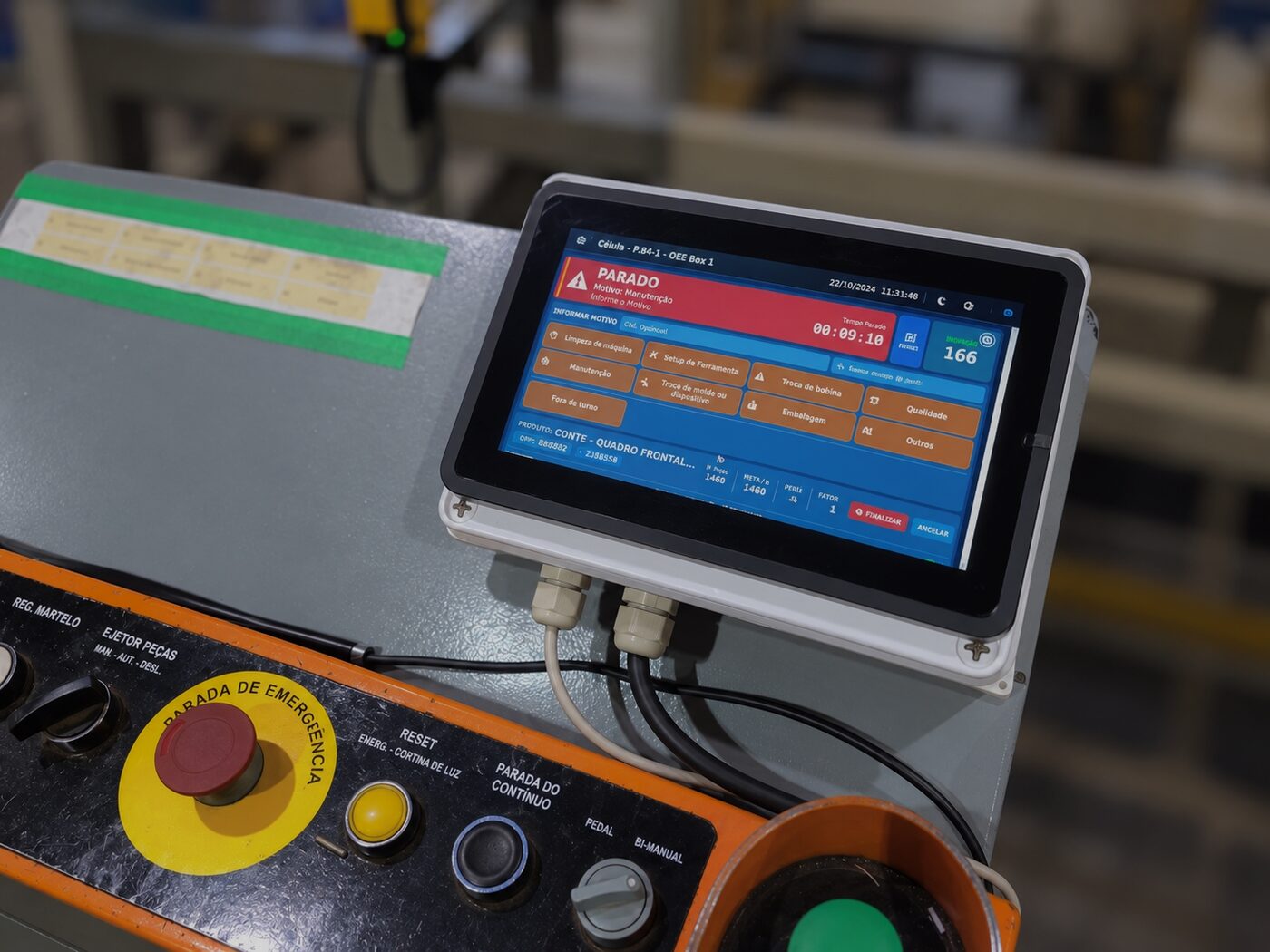 OEE Box com tela touch instalado ao lado do painel de comando de uma prensa, mostrando a tela de parada